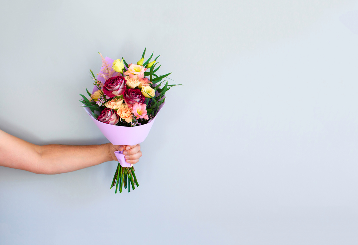 Hand with a bouquet of flowers.